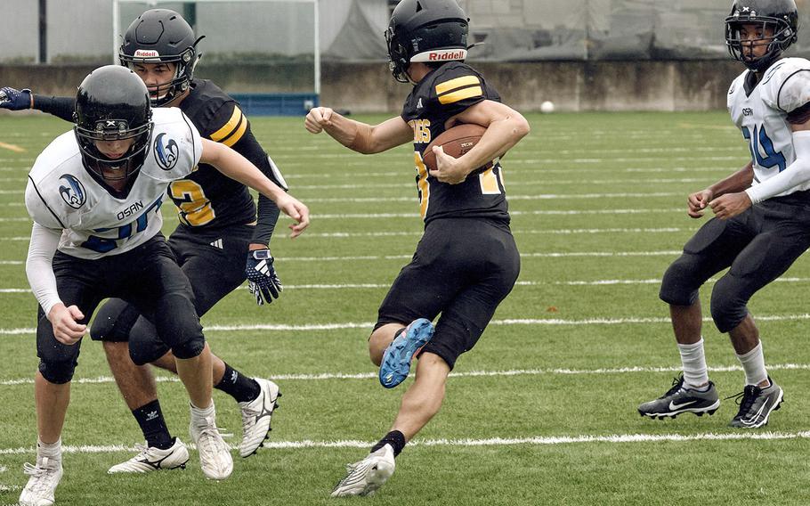 American School In Japan's Alex Moores runs between two Osan defenders.