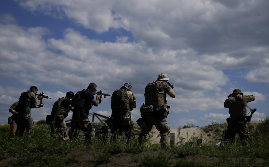 Civilian militia men hold rifles during training at a shooting range in outskirts Kyiv, Ukraine, Tuesday, June 7, 2022. 