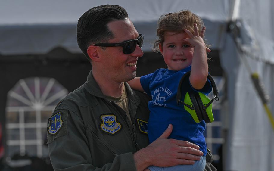 Maj. Joshua Gilly, 19th Airlift Wing Commander’s Action Group chief, and his child enjoy the Thunder Over the Rock Air Show at Little Rock Air Force Base, Oct. 21, 2023. 