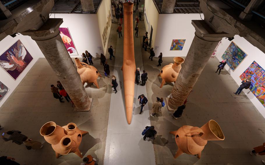 Visitors browse among clay sculptures by Argentinian artist Gabriel Chaile at the Venice Art Biennale. Chaile's work with various materials, forms and archetypal symbols explores impoverished communities, rituals and artistic customs from his home in South America.