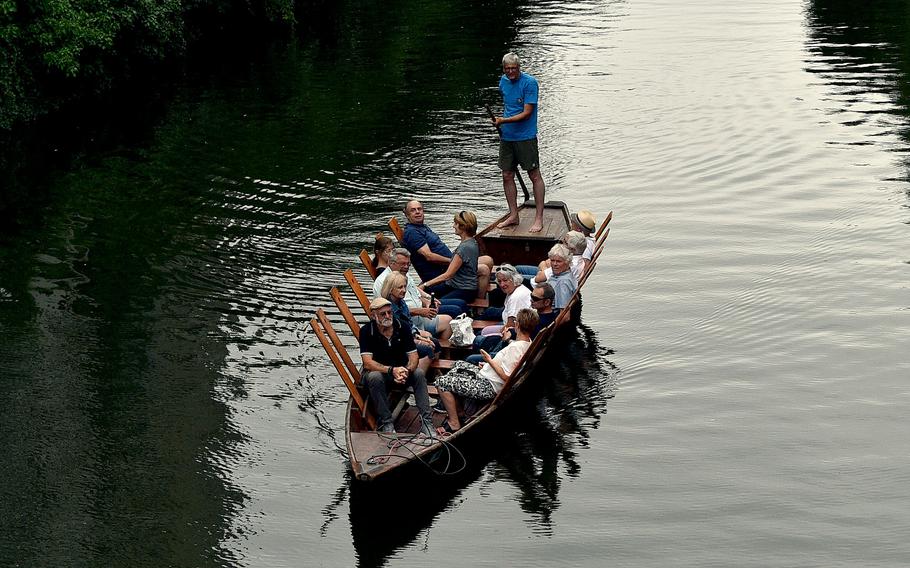 People sit in a small boat on a river.