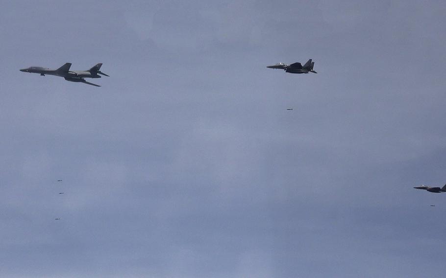 An Air Force B-1B Lancer, left, drops joint direct attack munitions alongside South Korean F-15K Slam Eagles over South Korea, Wednesday, June 5, 2024. 