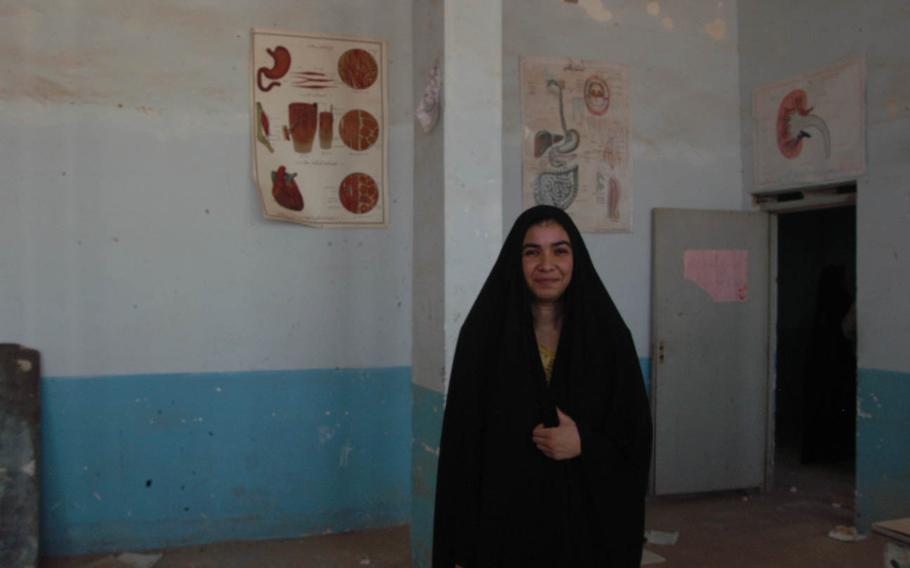 A teacher stands in the remains of her classroom