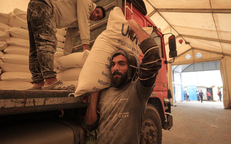 A man hefts a 25-kilogram bag of flour at a relief station where UNRWA, the U.N. agency for Palestinian affairs, distributes supplies.