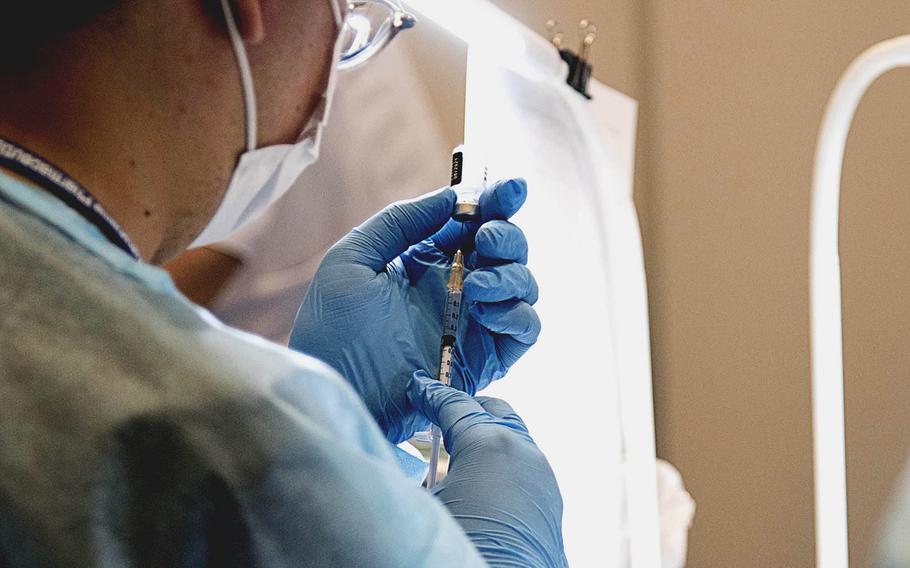 A medical technician prepares a dose of coronavirus vaccine at a mass vaccination site in Yokohama, Japan, May 17, 2021. 