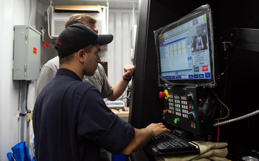 Petty Officer 2nd Class Fernando Munguia, a machinery repairman aboard the USS Essex, sets up an ElemX 3D printer aboard the amphibious assault ship during Rim of the Pacific drills near Hawaii, July 12, 2022.