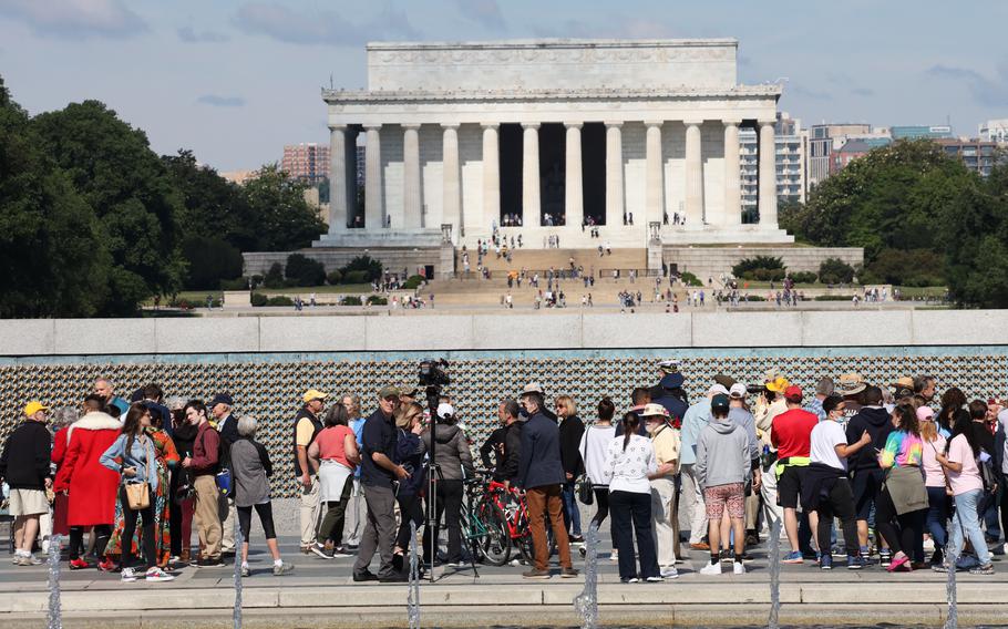 With the Lincoln Memorial as a backdrop, members of the public meet participants in a Memorial Day ceremony at the National World War II Memorial in Washington, D.C., May 31, 2021.