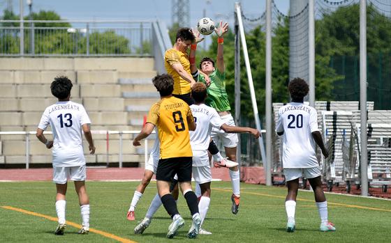 Lakenheath goalkeeper Matthew Vasquez and Stuttgart striker Seth Harpuder jump for a ball during a Division I semifinal match at the 2025 DODEA European championships on May 21, 2025, at Kaiserslautern High School in Kaiserslautern, Germany.