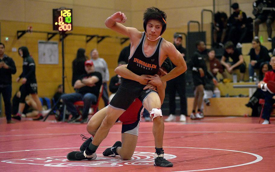 Spangdahlem's Troy Truscott stands up as Kaiserslautern's Chris De La Torre holds on during a 126-pound match at a wrestling meet on Dec. 9, 2023, at Kaiserslautern High School in Kaiserslautern, Germany.