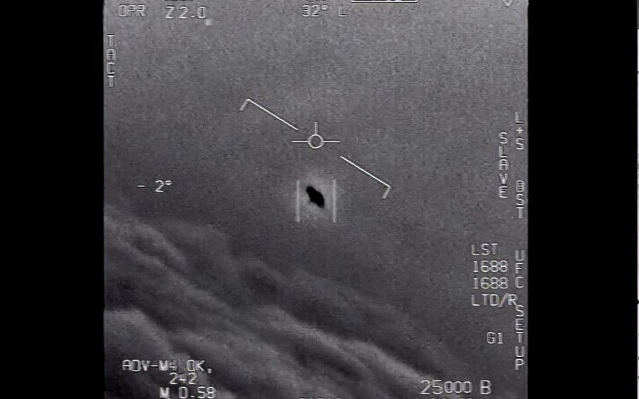 A screen grab shows an unexplained object, seen at center, while being tracked in 2015 as it soars high along the clouds, traveling against the wind. “There's a whole fleet of them,” one naval aviator tells another, though only one indistinct object is shown. “It's rotating."