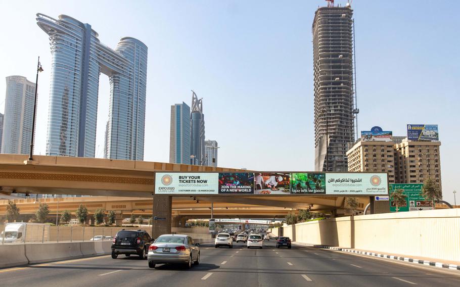 Motorists drive under a digital advert for Expo 2020 Duabi on Sheikh Zayed Road in downtown Dubai, United Arab Emirates, on Sept. 28, 2021. 