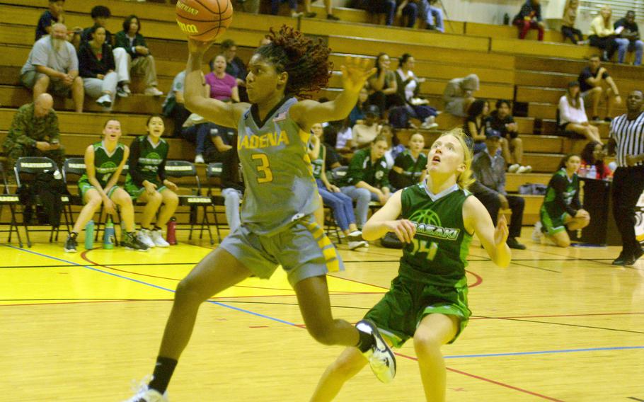 Kadena's NyKale Penn drives past Kubasaki's Bella Clark during Friday's DODEA-Okinawa girls basketball game. The Panthers won 40-12.