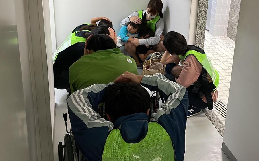 People simulate taking shelter during an evacuation drill in Yonaguni, Okinawa, Japan, on Nov. 30, 2022. 