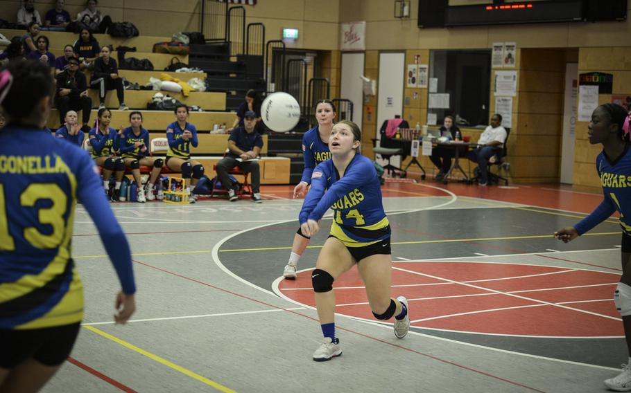 Sigonella Jaguar Isabelle Balleza manages a dig, fielding the ball from over the net, as teammate Rickalia Goss observes from the right during their match against the Brussels Brigands at the DODEA Division III European volleyball semifinal on Oct. 27, 2023, in Kaiserslautern, Germany.