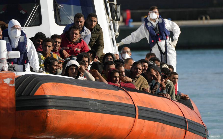 Des migrants et des réfugiés entrent dans le port de Roccella Jonica, dans la région de Calabre, dans le sud de l'Italie, le dimanche 14 novembre 2021. Les garde-côtes italiens ont secouru dimanche matin au large de la Calabre plus de 250 jeunes hommes et garçons, pour la plupart d'origine égyptienne. 