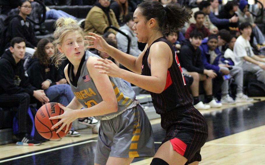 Kadena's Cassidy Kimbrough tries to work around Kinnick's Kotone Turner during the Panthers' 32-24 win over the Red Devils on Tuesday.