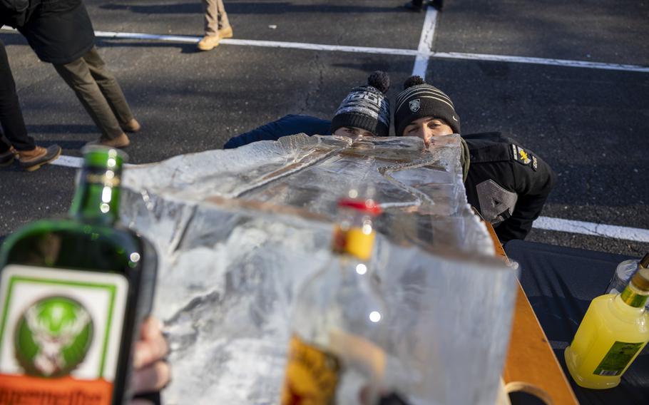 Two fans drink booze poured down a sheet of ice. Luge shots.