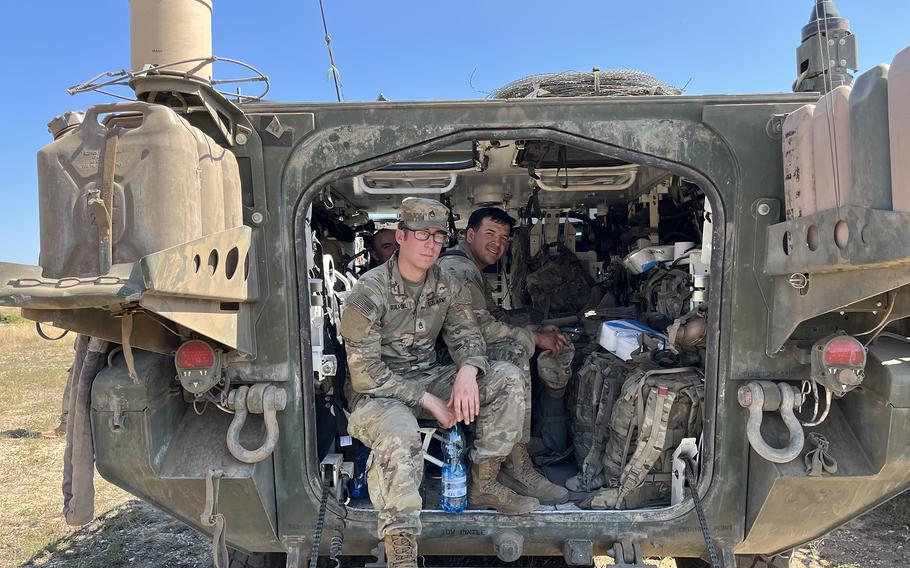 A U.S. Army Stryker crew relaxes in the back of a military vehicle during downtime at exercise Saber Guardian.