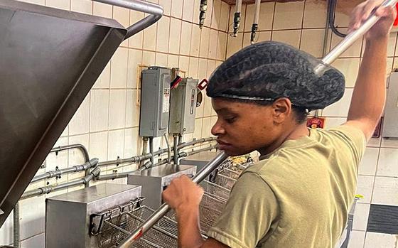 Army Reserve Sgt. Nichole Hall, deployed to Camp Arifjan, Kuwait, with the Indianapolis-based 310th Sustainment Command (Expeditionary), stirs chili at the North Dining Facility at Bagram Airfield, Afghanistan during her 29-day assignment there which ended July 2, 2021, as the U.S. base closed.