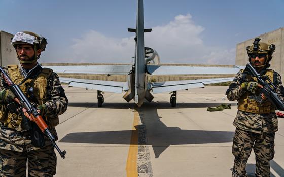 Taliban fighters stand guard behind an airplane left by U.S. forces at Hamid Karzai International Airport in Kabul, Afghanistan, Tuesday, August 31, 2021. (Marcus Yam/Los Angeles Times/TNS)