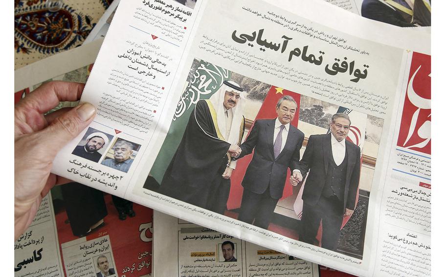 A man in Tehran holds a local newspaper reporting on its front page the China-brokered deal between Iran and Saudi Arabia to restore ties, signed in Beijing the previous day, on March, 11 2023.  
