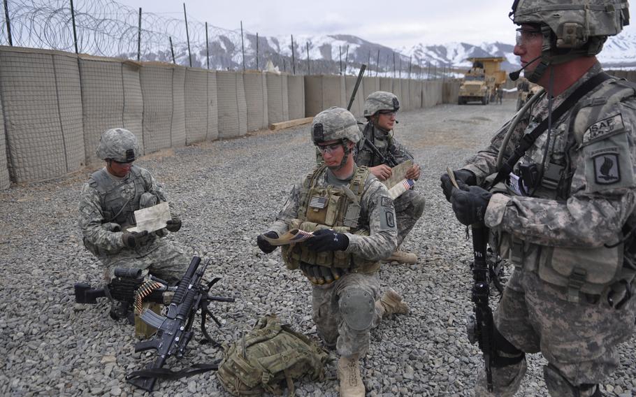 Soldiers with the 173rd Airborne Brigade’s B Company pack their "blood chits," a request for shelter that is translated into several languages in case of separation from the unit, before an air assault mission in Wardak province, southwest of Kabul. The company is working to make inroads with local villagers before the traditional summer fighting season.