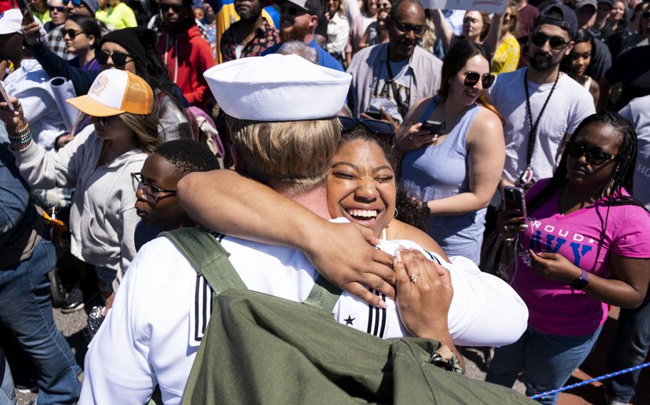 A woman hugs sailors as they return from deployment with the USS George H.W. Bush at Naval Station Norfolk in Norfolk, Va., on April 23, 2023.