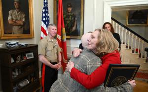 Joyce LaLonde embraces Patrisha Smith, in red, the wife of Gen. Eric M. Smith, left, as Gen. Smith recognizes Joyce and others during the ceremony Thursday. MUST CREDIT: Matt McClain/The Washington Post