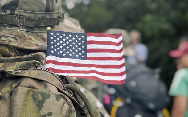 A miniature American flag peeks out of a troop’s backpack.