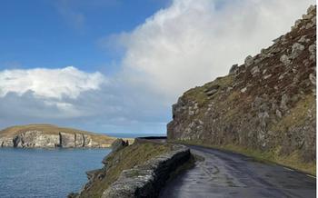 Ireland road with hill on the right side and water on the left side