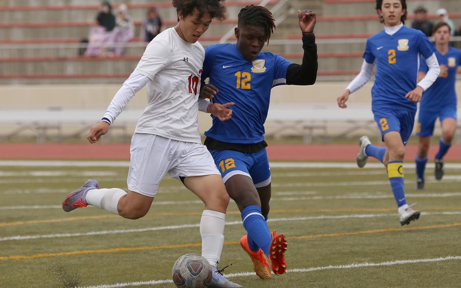 E.J. King's Kyo Tominaga and Yokota's Jai Bailey run down the ball during Monday's Division II boys soccer match. The Panthers won 1-0.