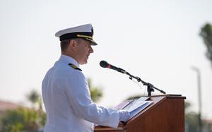 A sailor speaks at a podium.