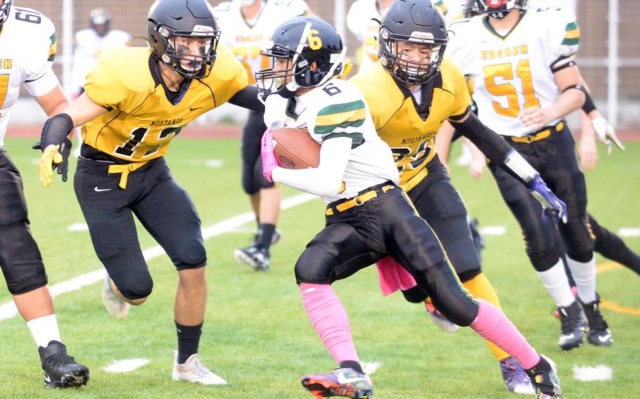 Robert D. Edgren running back Philip John Lorenzo tries to race past American School In Japan defenders James Curtis and Isreal Rodriguez.