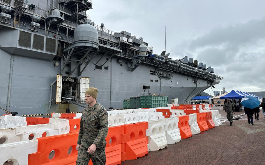 A U.S. Marine walks alongside the amphibious assault ship USS Makin Island in Busan, South Korea, Thursday, March 23, 2023.