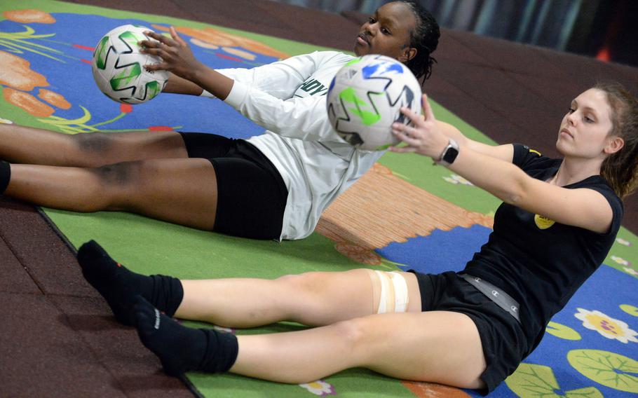 Robert D. Edgren freshman Anaiah Cain and senior Karin Lozier stretch prior to Eagles girls soccer practice at Misawa Air Base’s indoor Weasel’s Den.