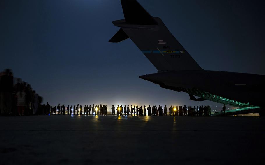 An aircrew assigned to the 816th Expeditionary Airlift Squadron prepares to load qualified evacuees aboard a U.S. Air Force C-17 Globemaster III in support of Afghanistan evacuation at Hamid Karzai International Airport, Afghanistan, Aug. 21, 2021. 