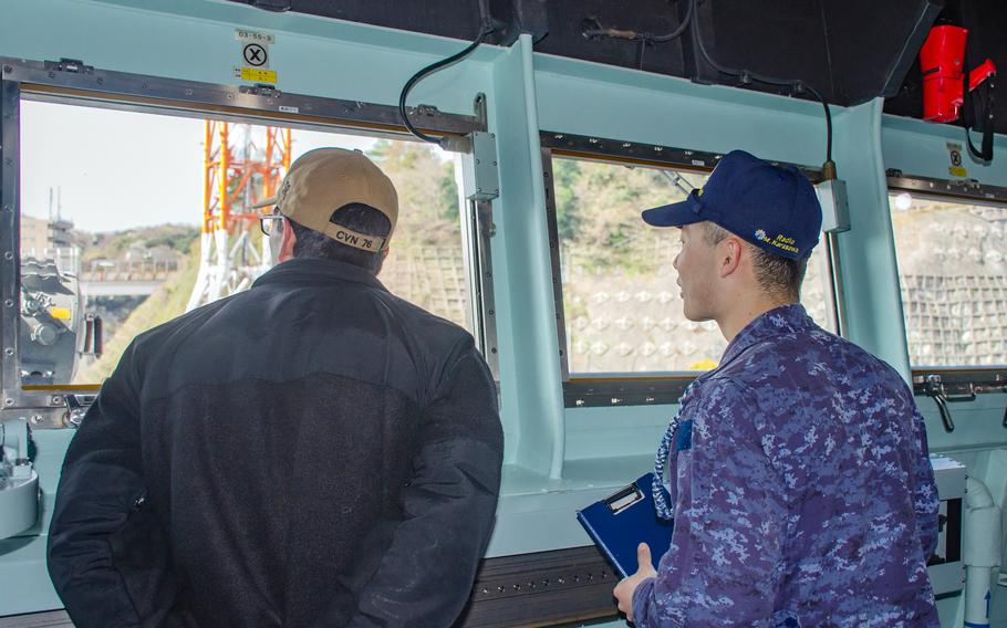 Petty Officer 1st Class Adrian Gonzales chats with a JS Izumo sailor during a tour of the Japanese carrier in Yokosuka, Japan, April 2, 2024.