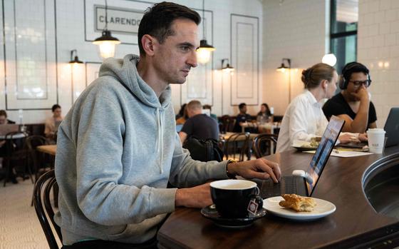 Financial analyst Timothy Mancari sits in a café as he works remotely in Arlington, Virginia, on May 25, 2023. The pandemic forced Americans to work from home. And now, more than three years on, employers are struggling to bring them back to the office. A third of employees in the US currently have complete freedom about where they work, compared with just 18 percent in France, according to a recent ADP study of 17 countries. (Andrew Caballero-Reynolds/AFP/Getty Images/TNS)
