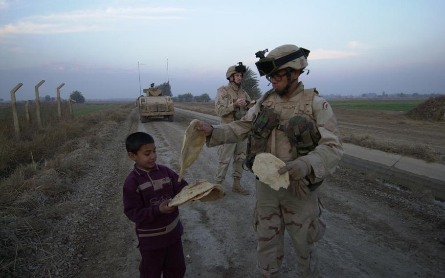 A boy gives a soldier flatbread