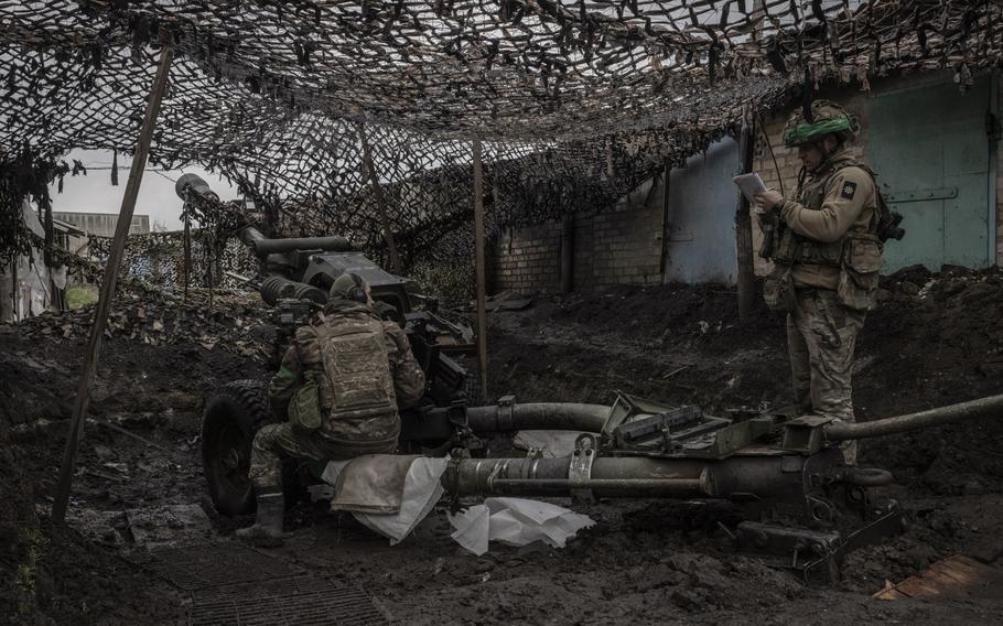 Soldiers with the call signs "Samurai," left, and "Crane" in Ukraine's 77th Brigade set correction coordinates after firing a howitzer on the outskirts of Chasiv Yar in Donetsk on April 21, 2023.