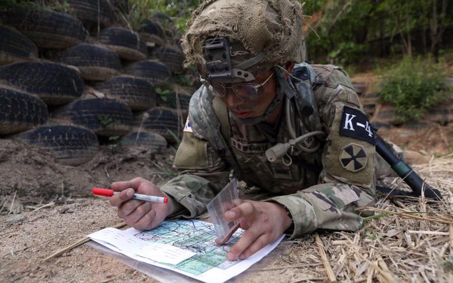 Army circuit.  Kang Young Hyun plots points on a map during a Best Warrior land navigation challenge at Camp Casey, South Korea, May 8, 2022.