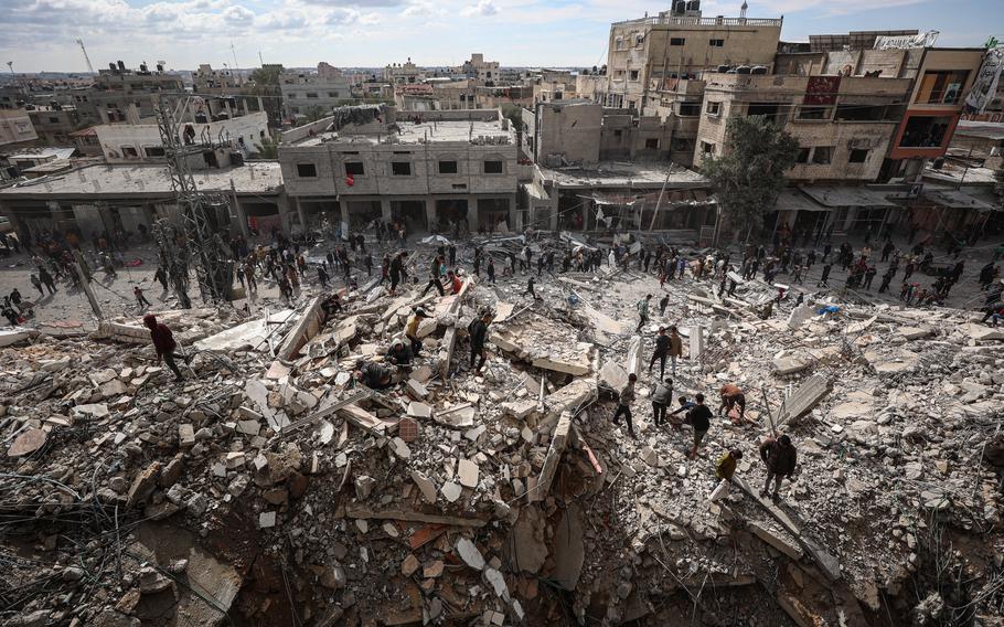 Palestinians inspect their homes after Israeli strikes hit the Al-Masry Tower on March 9 in Rafah. 