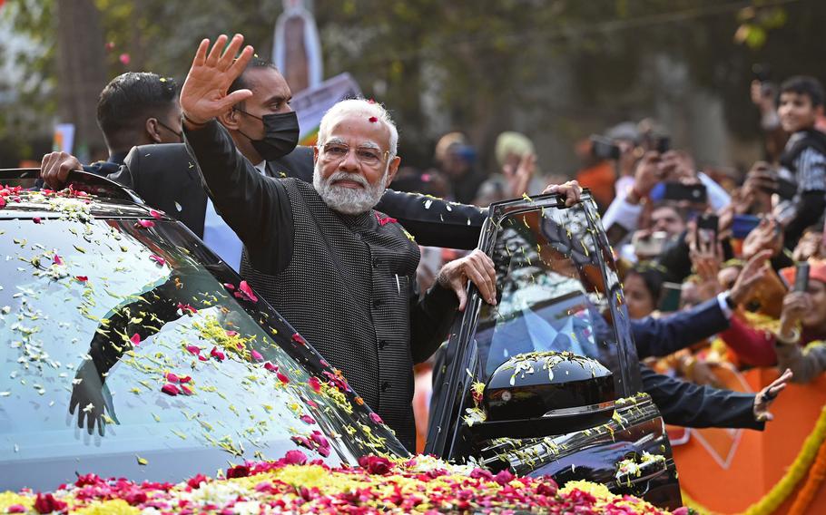 India’s Prime Minister Narendra Modi waves to his supporters during a roadshow ahead of the BJP national executive meet in New Delhi on Jan. 16, 2023. 