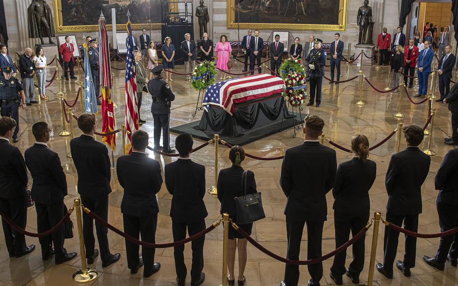 As a crowd of onlookers circle around, Sen Jon Tester, D-Mont., observes a moment of silence as he pays his respects before the casket of World War II Medal of Honor recipient Hershel Woodrow "Woody" Williams, who was lying in honor at the U.S. Capitol in Washington, on July 14, 2022.