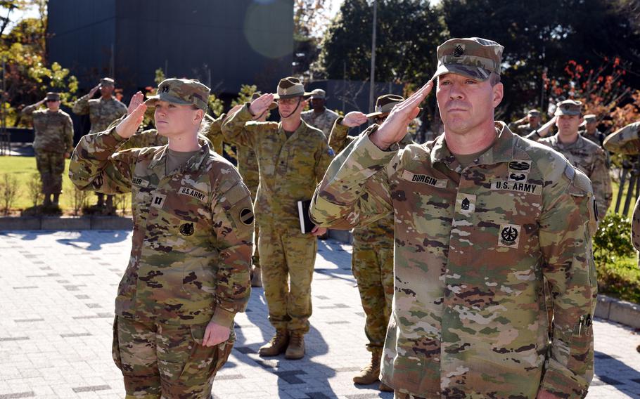 U.S. and Australian service members salute at Camp Asaka. 