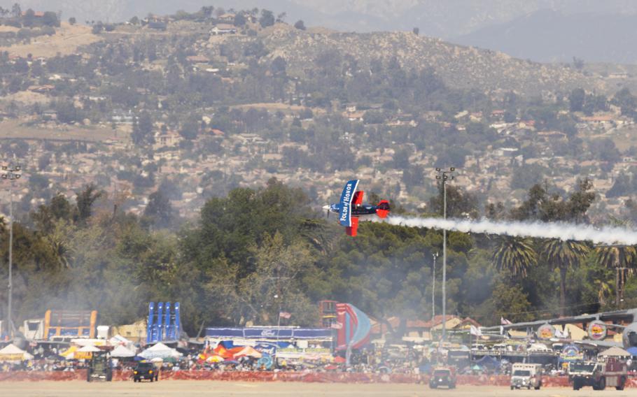 A stunt plane thrills a packed crowd
