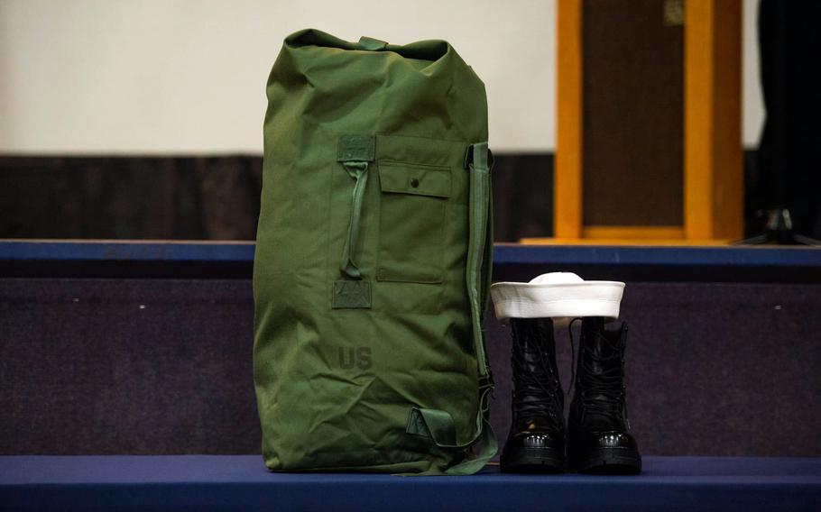 A sea bag, cap and boots are displayed aboard the aircraft carrier USS Theodore Roosevelt in honor of Petty Officer 3rd Class Jacob Slocum.