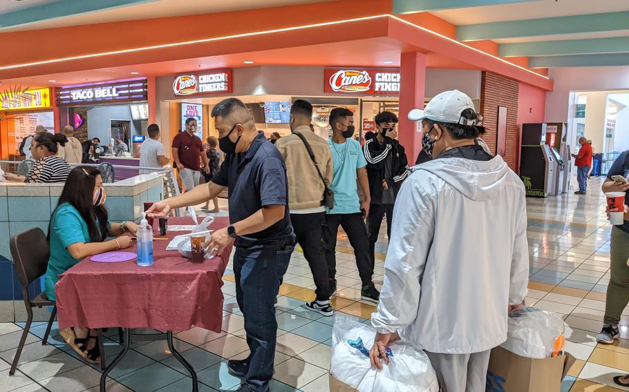 Diners show their vaccination record and registered phone number before entering Micronesia Mall food court on Aug. 30, the day when Guam reinstated a mask mandate and social distancing rules for indoor venues. 