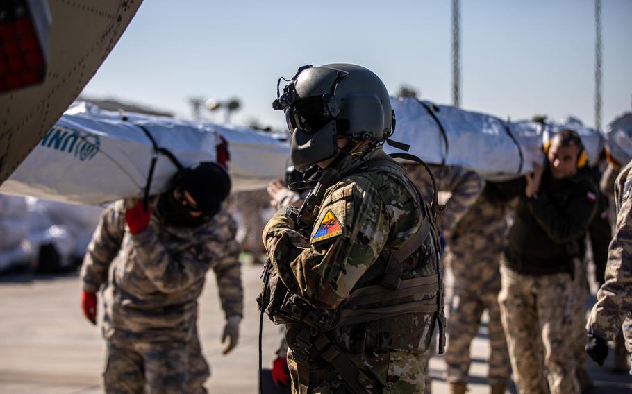 U.S. Army 1st Sgt. Christopher Norris, a CH-47F Chinook crew chief, supervises as his aircraft is loaded with tents from the U.N. Refugee Agency at Incirlik Air Base, Turkey, Tuesday, Feb. 14, 2023.