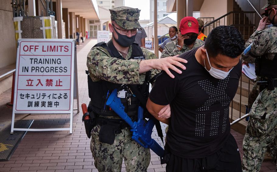 Petty Officer 1st Class James Eggers detains an actor playing an armed suspect during the Citadel Pacific exercise outside the exchange at Yokosuka Naval Base, Japan, July 20, 2021. 